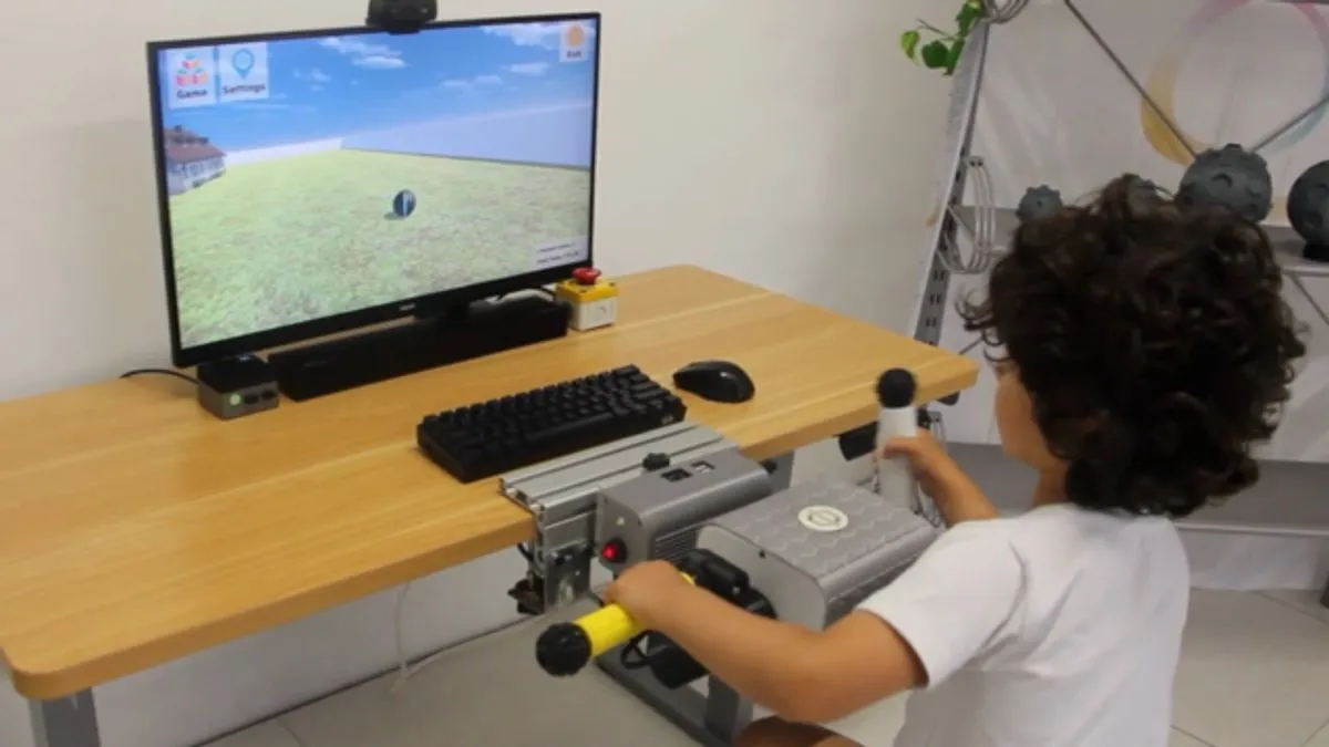 Ein Kind spielt an einem Tisch ein PhiCube-Spiel und hält in jeder Hand einen Griff.