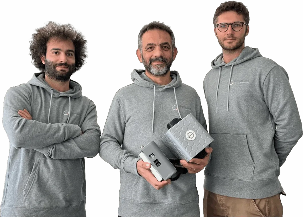 The three founders side by side in grey Rehabilia hoodies; Matteo Malosio, in the middle, holds two PhiCube units.
