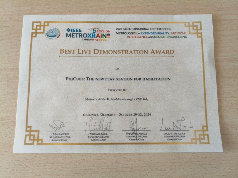 The Best Live Demonstration Award certificate of the 2026 IEEE MetroXRAINE conference, made out to “PhiCube: The new play station for habilitation”, presented by Matteo Lavit Nicora, Chemnitz, 20–22 October 2026.