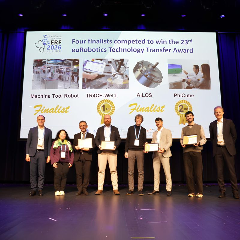 Los cuatro finalistas de la 23.ª edición del euRobotics Technology Transfer Award en el escenario, con PhiCube anunciado como segundo clasificado en la pantalla que tienen detrás.