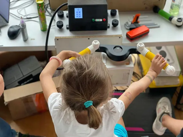 A girl reaches up to hold the grips of an early PhiCube prototype during a usability test, seen from above.