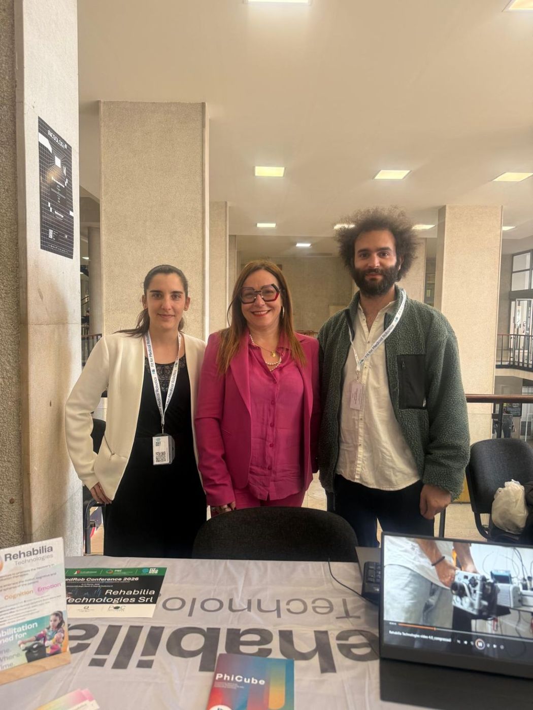 Trois membres de l’équipe Rehabilia Technologies sur leur stand à la conférence Fit For Medical Robotics 2026, à Naples.