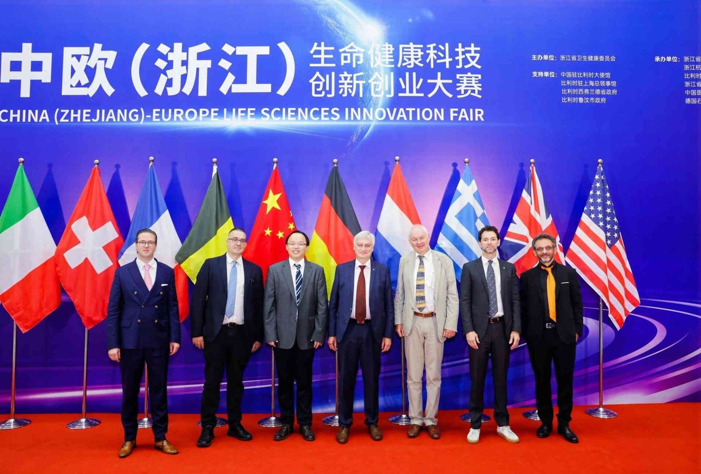 Mitglieder der europäischen Delegation posieren auf der Innovationsmesse ZELSIF in Hangzhou vor ihren Nationalflaggen.